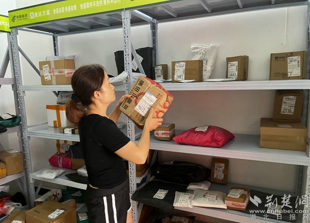在城北街道西十村寄遞物流綜合便民服務(wù)站，站點負責(zé)人正在對快遞包裹進行分類擺放  攝 余新怡攝.jpg